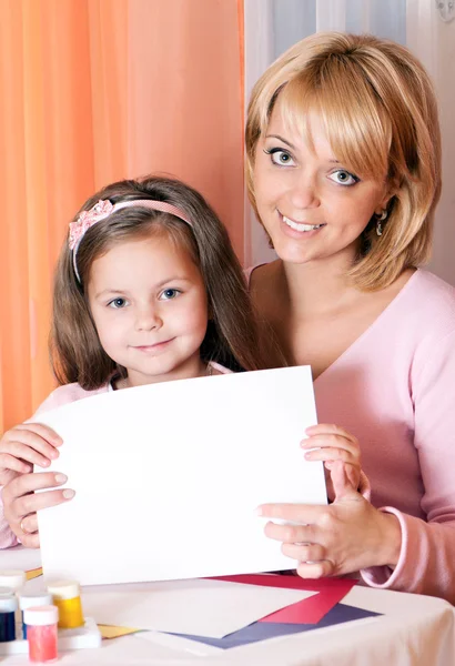 Beyaz bir sayfa tutan anne ile mutlu kız — Stok fotoğraf