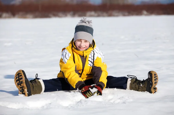 Junge setzt sich in den Schnee — Stockfoto