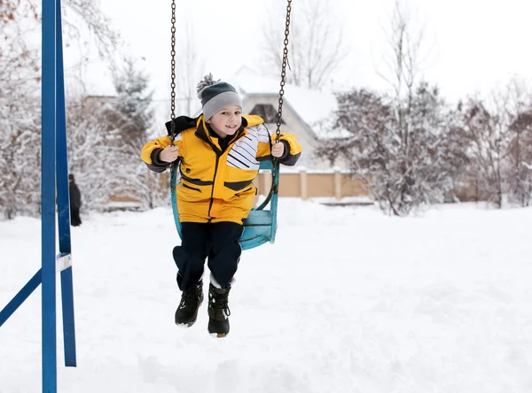 Barn på en gunga på vintern — Stockfoto