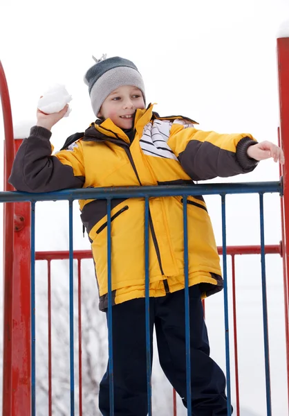 Chlapec hrát sněhové koule na dětské hřiště — Stock fotografie