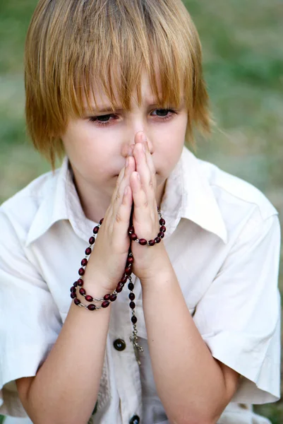 Мальчик молится на улице — стоковое фото