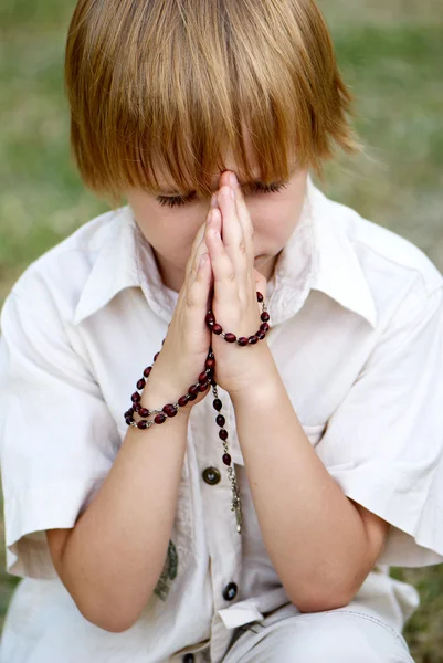 Jovem menino orando ao ar livre — Fotografia de Stock