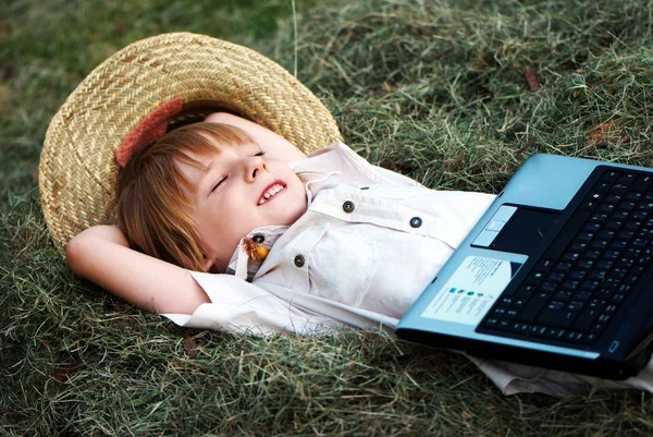 Chlapec čtení zápisník ležící v kupce sena — Stock fotografie