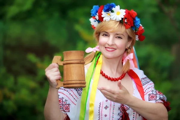 Mulher ucraniana feliz com uma caneca de madeira — Fotografia de Stock