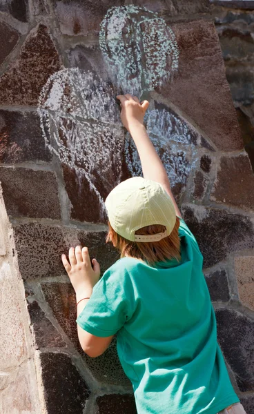 O menino desenhando balões em uma parede de pedra — Fotografia de Stock
