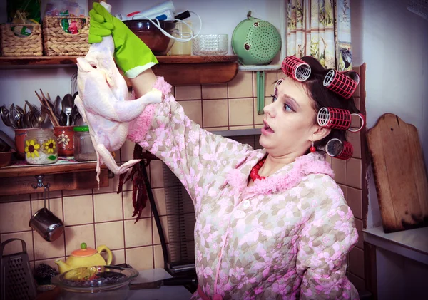 A dona de casa boba com carcaça de uma galinha em mãos — Fotografia de Stock