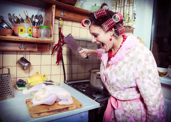De dwaze huisvrouw met slager in handen en karkas van een kip — Stockfoto