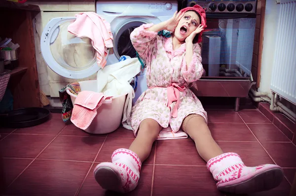 Ung hemmafru med tvättmaskin och handdukar. — Stockfoto