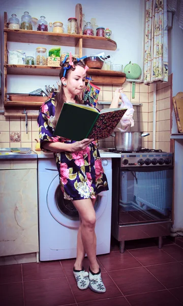 Fåniga hemmafru med bok och kadavret av en höna i händer — Stockfoto