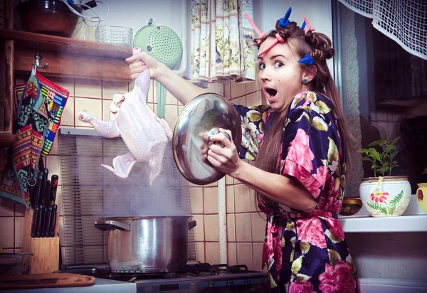 The silly housewife with carcass of a hen in hands — Stock Photo, Image