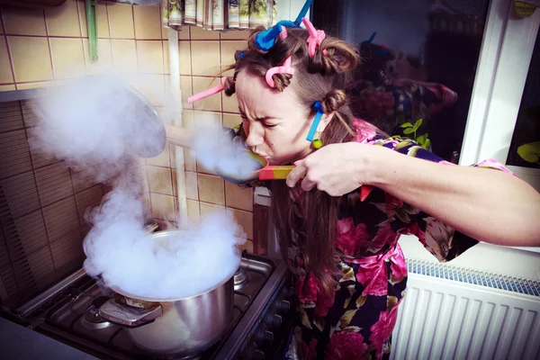 Jovem mulher degustando sua refeição em sua cozinha — Fotografia de Stock