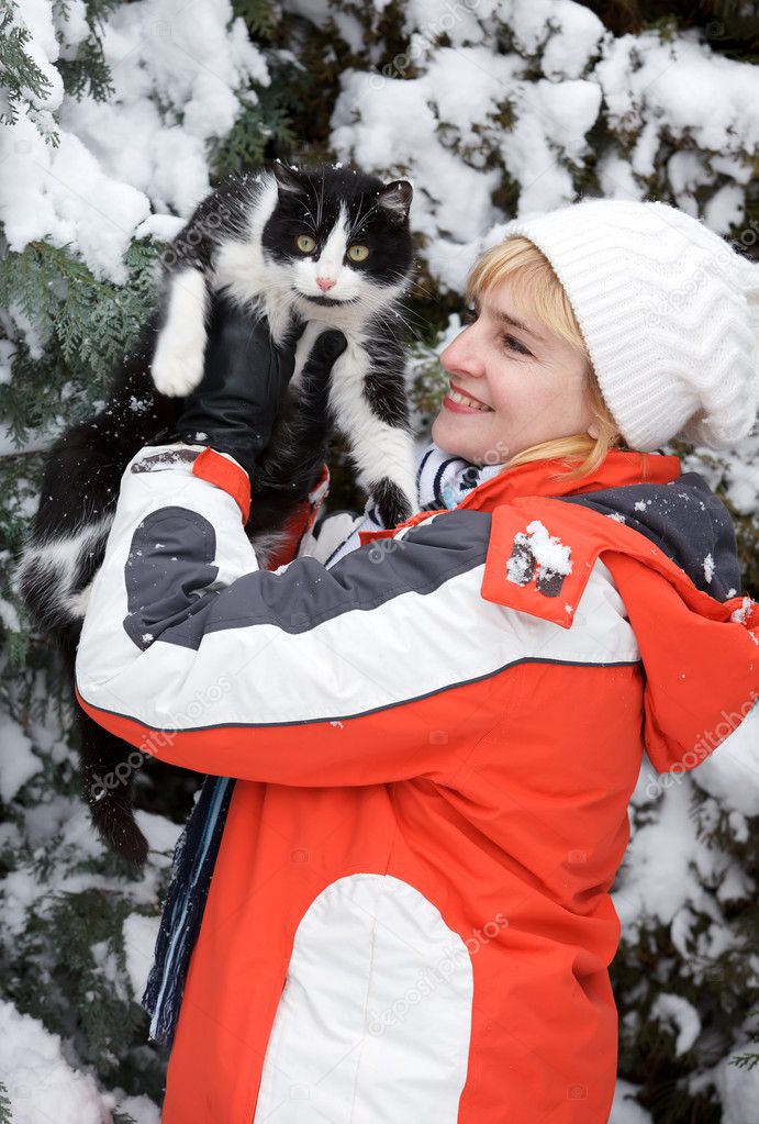 The woman with a cat in hands in winter park