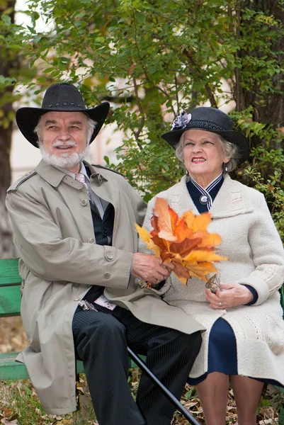 Happy old coule in autumnal park — Stock Photo, Image