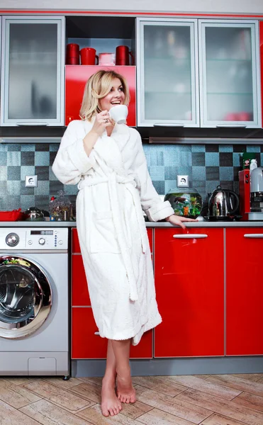Mulher branca jovem bonita na cozinha bebendo chá quente — Fotografia de Stock