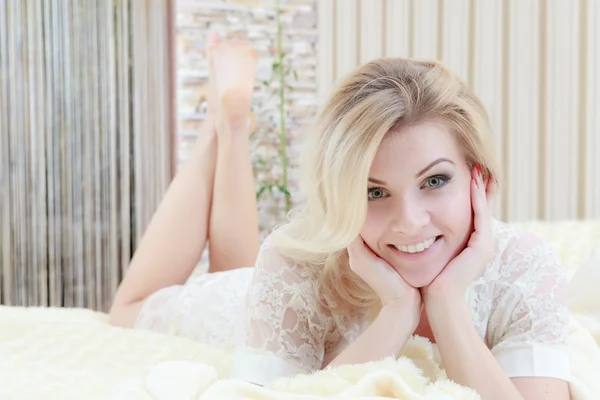 Mladá krásná žena ležící v posteli — Stock fotografie