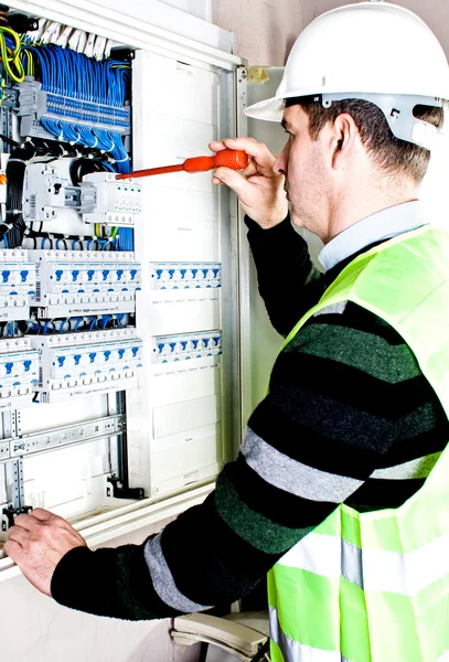 Eletricista verificando uma caixa de fusíveis — Fotografia de Stock