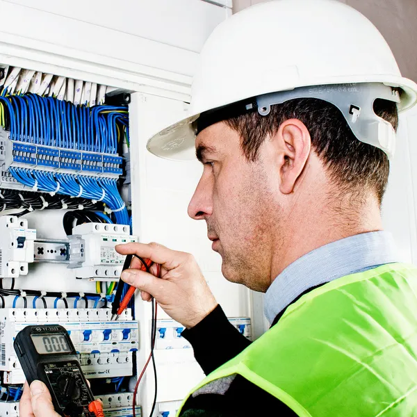 Eletricista verificando uma caixa de fusíveis — Fotografia de Stock