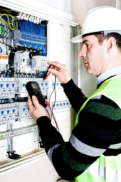 Electrician checking a fuse box Stock Photo