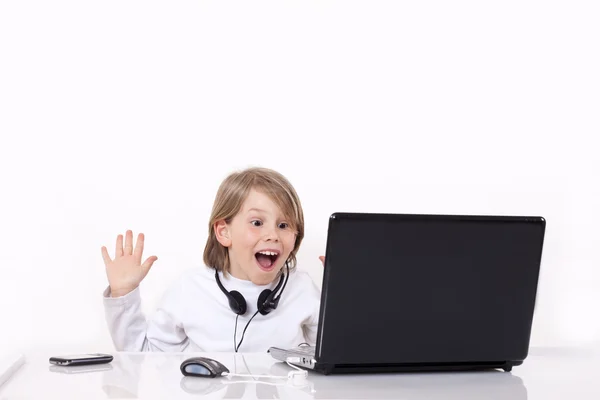 Счастливый ребенок удивлен за ноутбуком — стоковое фото