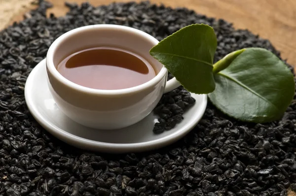 Ένα φλιτζάνι πράσινο τσάι με τα αξιοθετα φύλλα — Φωτογραφία Αρχείου
