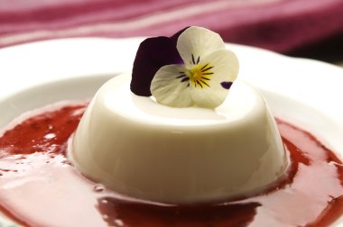 Vanilla panna cotta with berry sauce and spring flower clipart