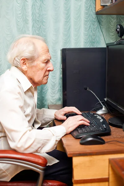 Старик работает за компьютером — стоковое фото