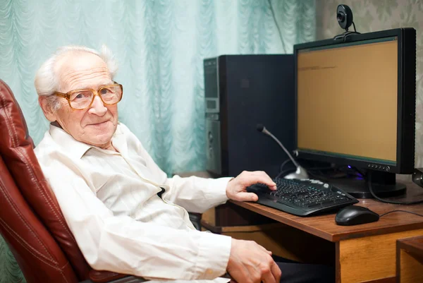 Homem velho satisfeito perto do computador — Fotografia de Stock