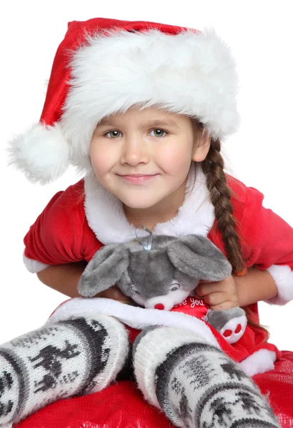 Portrét šťastná holčička s hračkou v santa claus oblečení — Stock fotografie