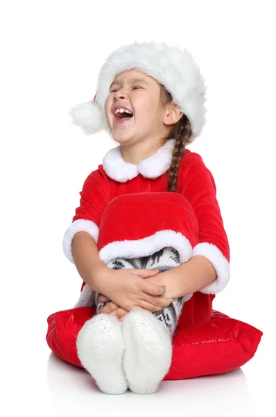Happy little girl in Santa hat laughs on a white background — Stock Photo, Image