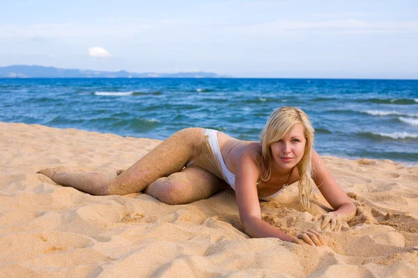 Schönes Mädchen am Strand liegend — Stockfoto