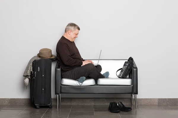 Średniej wieku człowiek używa laptopa. — Zdjęcie stockowe