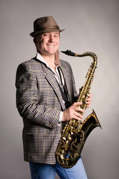 Lachende jonge man met een saxofoon. — Stockfoto