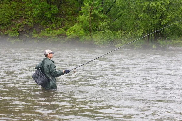 Рыбак ловит лосося на реке — стоковое фото