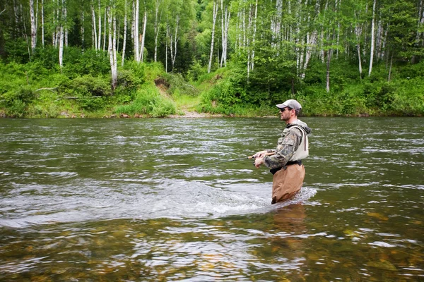 Fischer fängt Lachse im Fluss. — Stockfoto