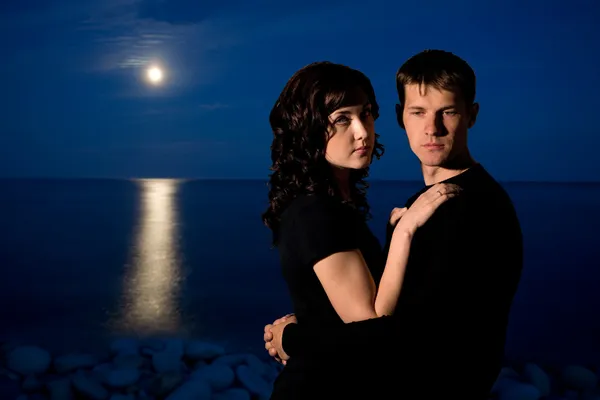 Jovem casal à noite junto ao mar — Fotografia de Stock
