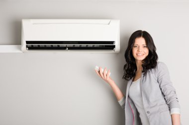 Girl holding a remote control air conditioner clipart