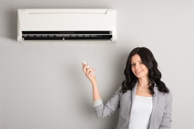 Girl holding a remote control air conditioner clipart