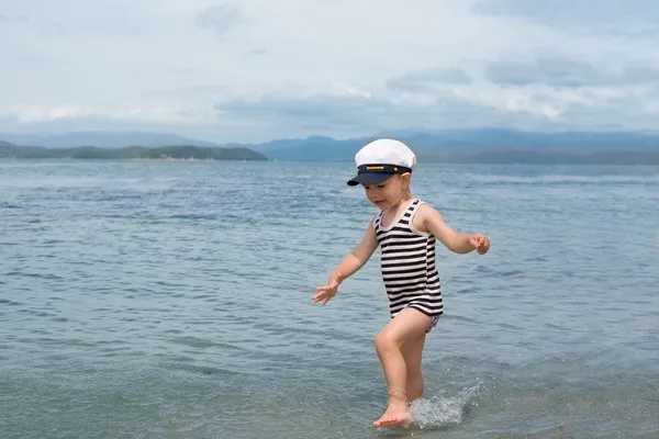 Μικρό αγόρι που τρέχει πέρα από τη θάλασσα. — Φωτογραφία Αρχείου
