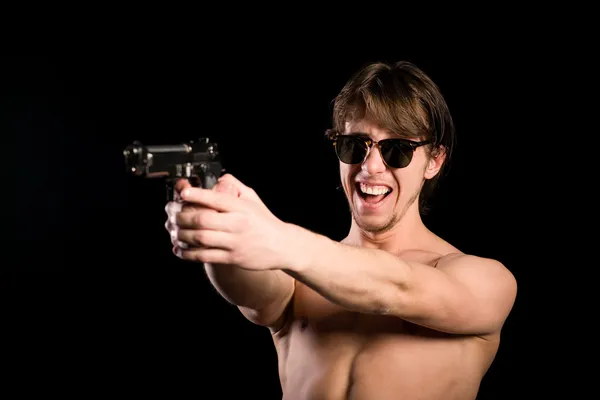 Seminude man firing a gun — Stock Photo, Image