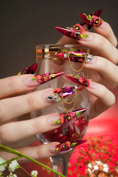 Manicure van mooie handen met een glas — Stockfoto
