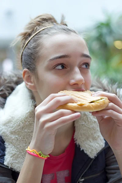 Девочка-подросток ест сэндвич — стоковое фото