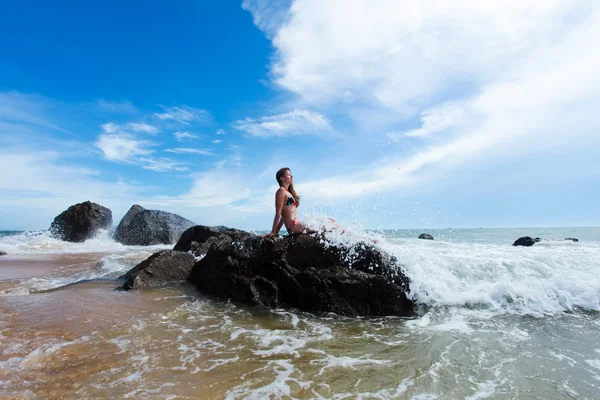 Женщина на скале в океане — стоковое фото