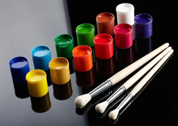 Secchi di vernice con pennelli su sfondo scuro — Foto Stock