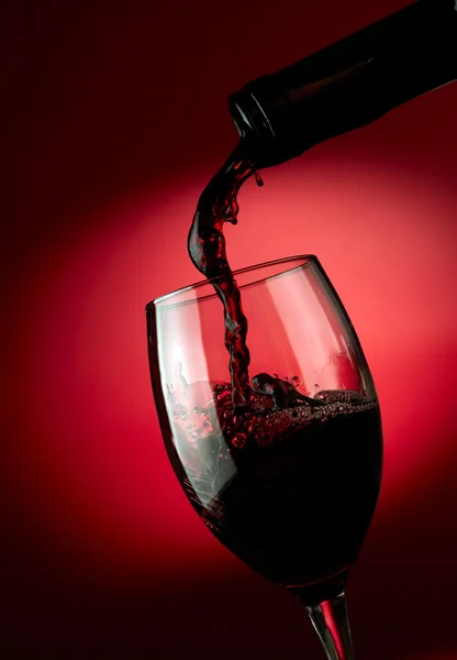 Rotwein im Glas vor dunklem Hintergrund — Stockfoto