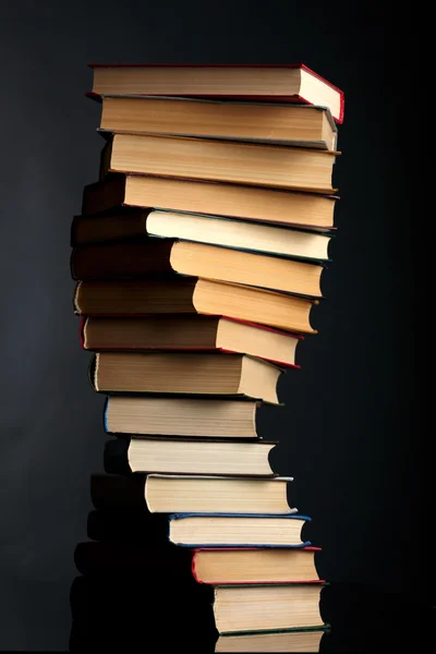 Högen av böcker på en svart bakgrund — Stockfoto
