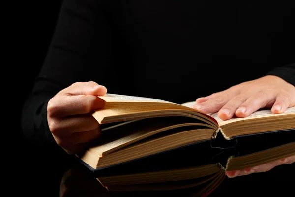 Open book in hands on black background — Stock Photo, Image