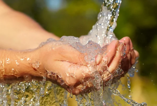 Las manos de la mujer con agua salpicada — Foto de Stock