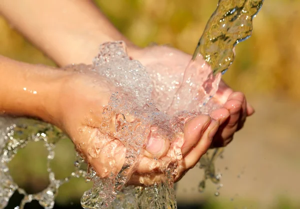 Mains de femme avec éclaboussure d'eau — Photo