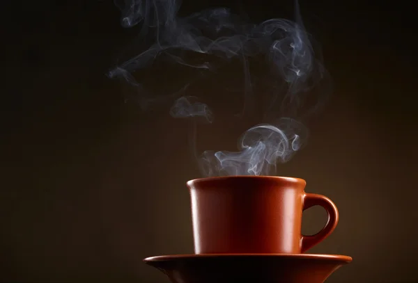 Cup of coffee with smoke over dark background — Stock Photo, Image
