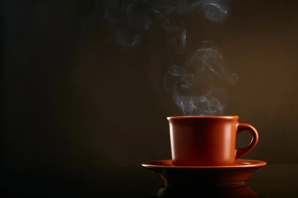 ถ้วยกาแฟที่มีควันบนพื้นหลังมืด — ภาพถ่ายสต็อก